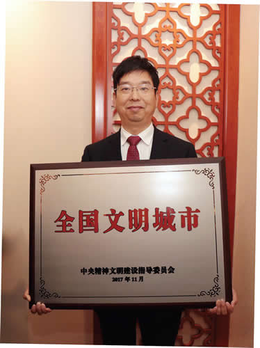 图为宜兴市委书记沈建在京领取全国文明城市奖牌.